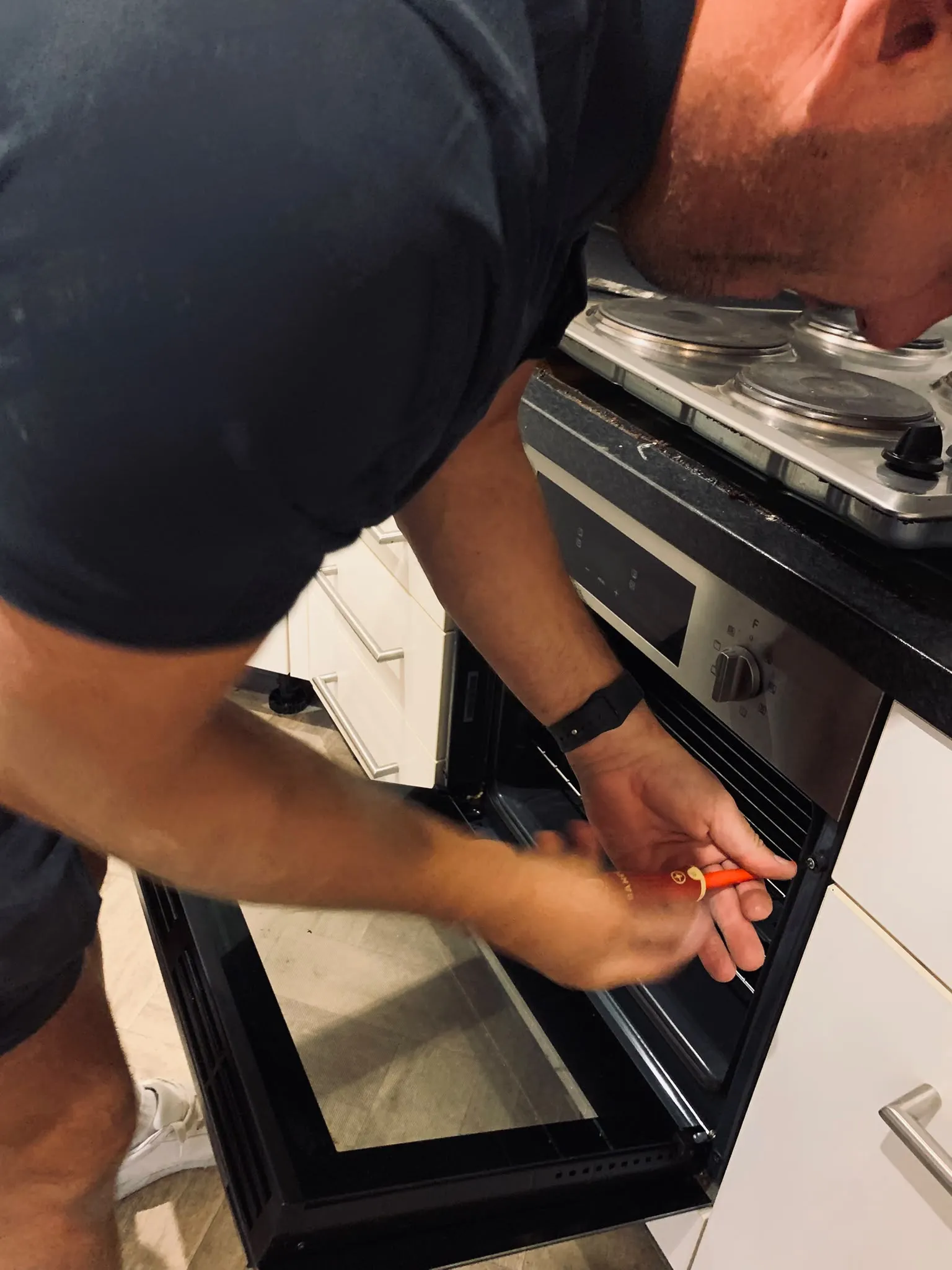 Ben working on the cooker during an electric to induction hob replacement