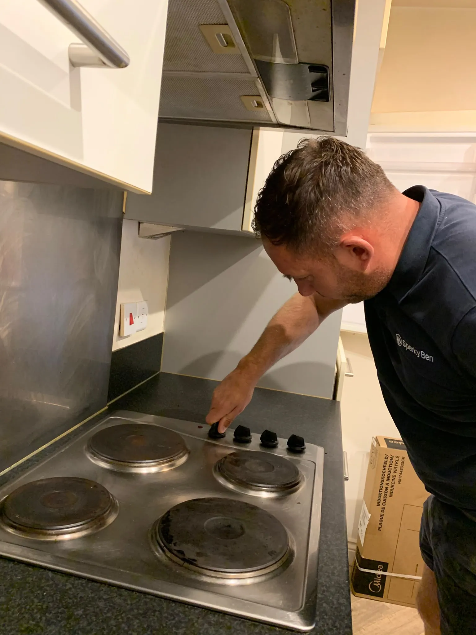 Ben working on the old electric hob before its replacement with an induction hob